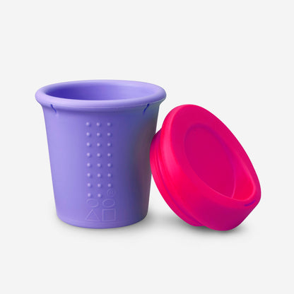 Child drinking from a reusable silicone kids travel mug on the go.
